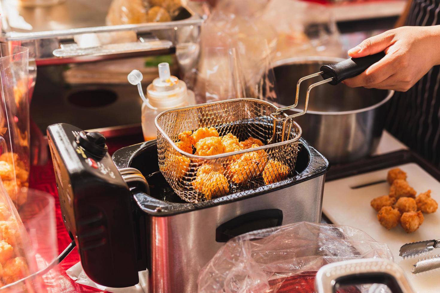 hembra cocinero profundo frito carne pelota en cocina. foto