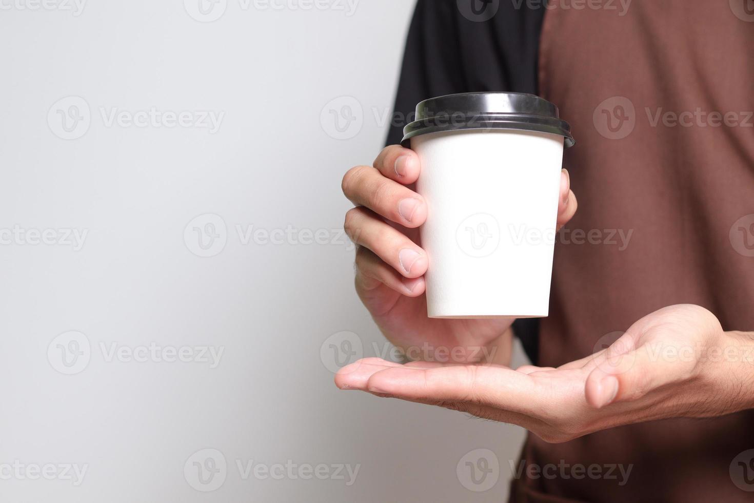 Mockup of barista male hand holding a coffee paper cup. Isolated image on white background with copy space photo