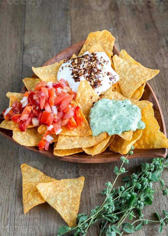 Cheese nachos with different types of sauce photo