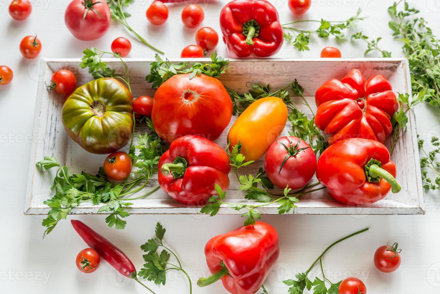 Fresh tomatoes and peppers on the wooden tray photo