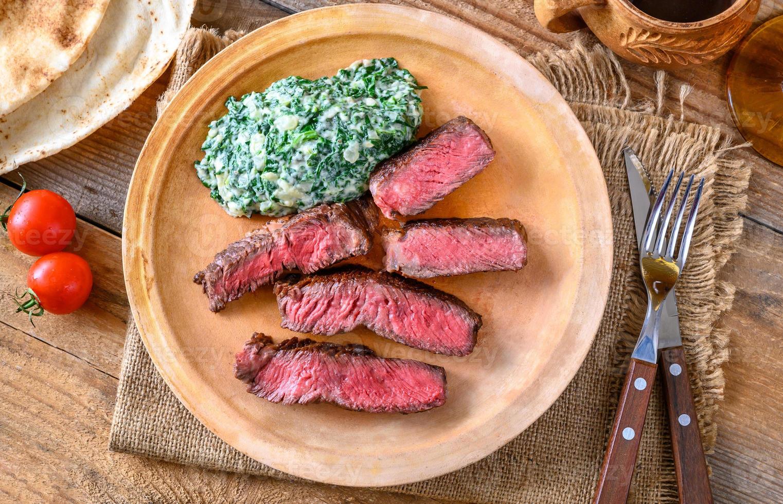 Beef steak with creamy spinach photo