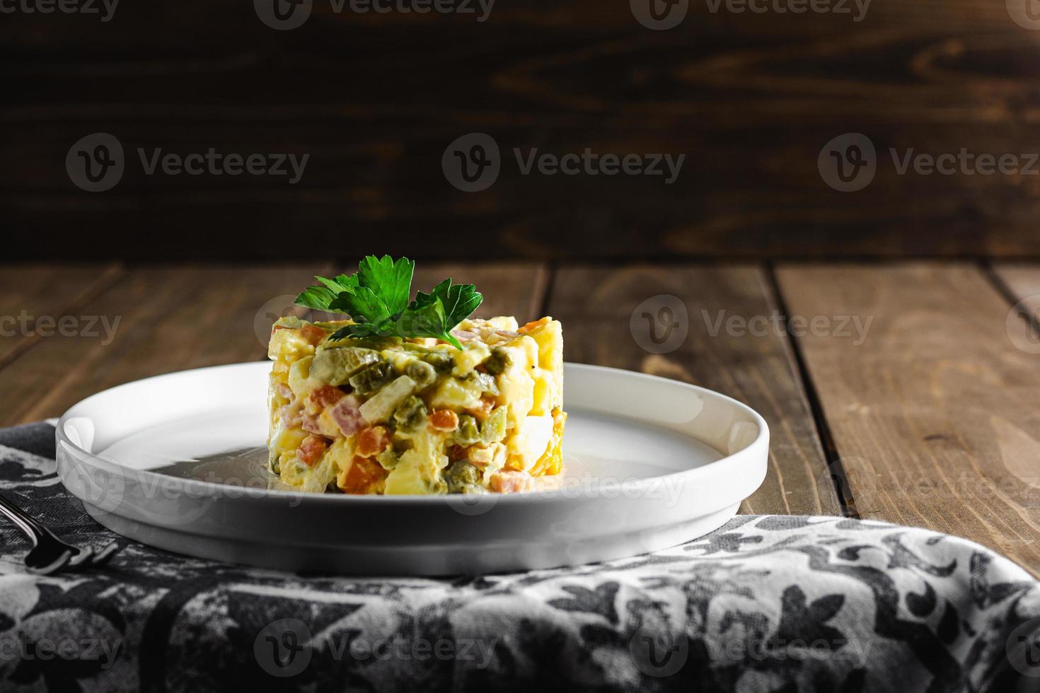Traditional russian salad Olivier with mayonnaise in bow with copy space. photo