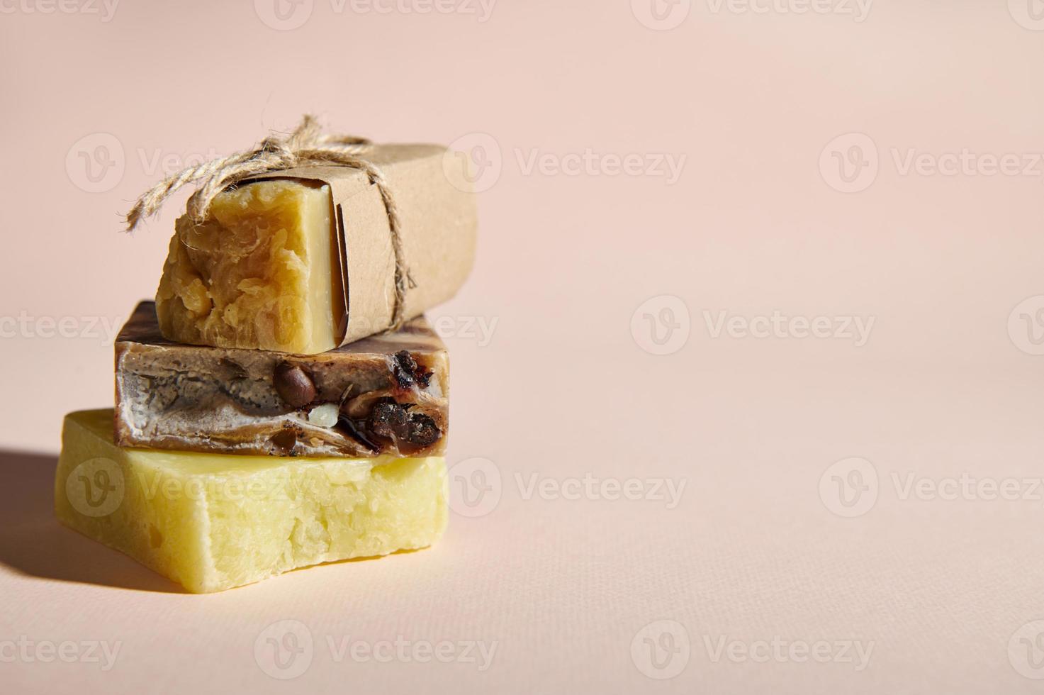 Still life cold pressed natural craft soap bars and solid shampoos with organic ingredients, stacked on pink background photo