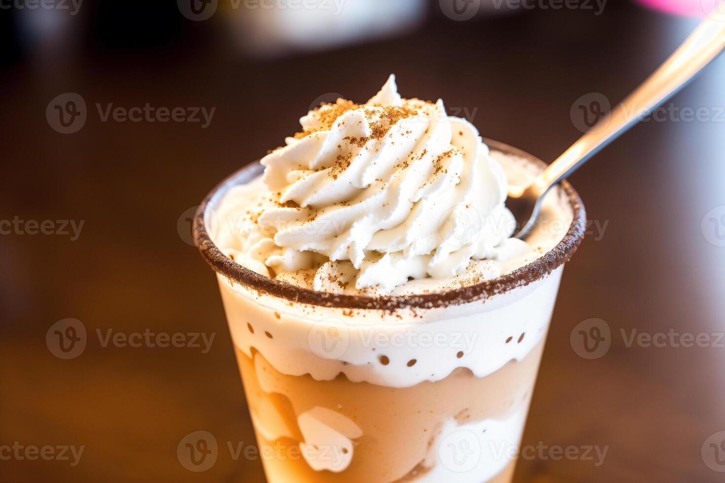 Iced coffee with whipped cream in a glass on a wooden table. photo