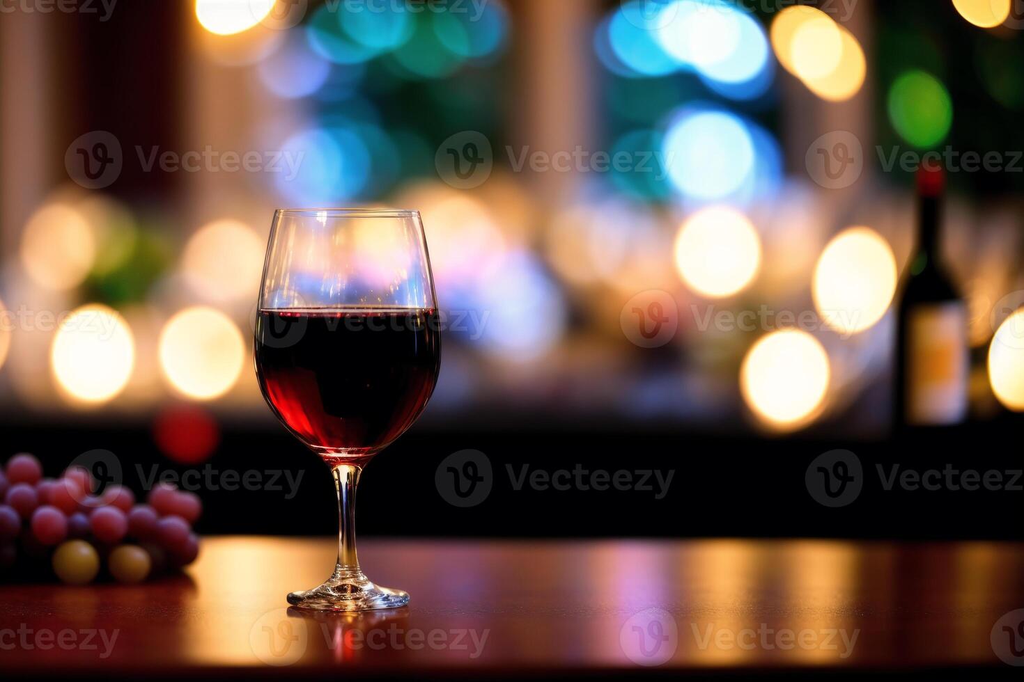 Glass of red wine and grapes on a wooden table.Bottle and glass of red wine with grapes. photo