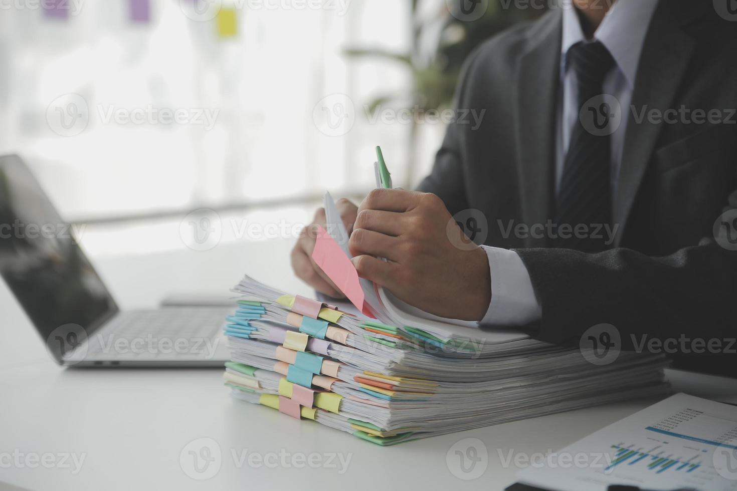 Asian Businesswoman Using laptop computer and working at office with calculator document on desk, doing planning analyzing the financial report, business plan investment, finance analysis concept. photo