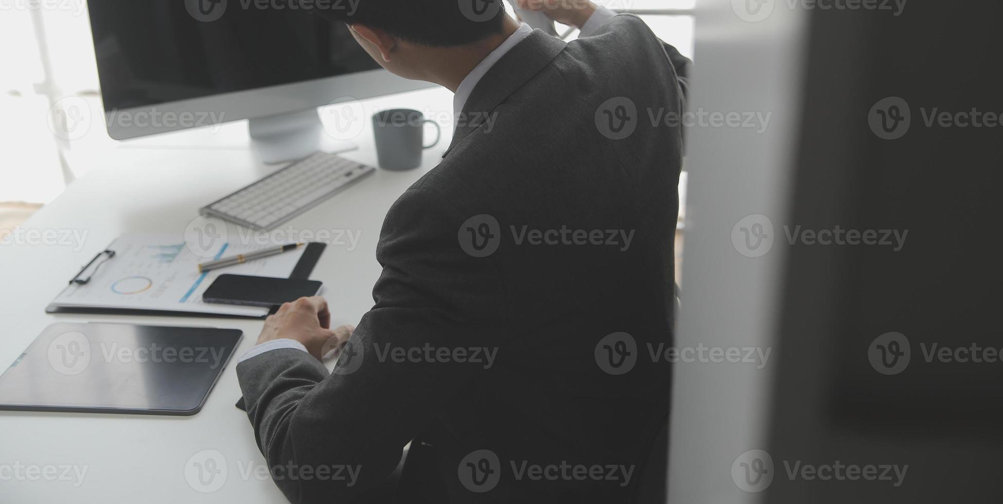 Asian Businesswoman Using laptop computer and working at office with calculator document on desk, doing planning analyzing the financial report, business plan investment, finance analysis concept. photo