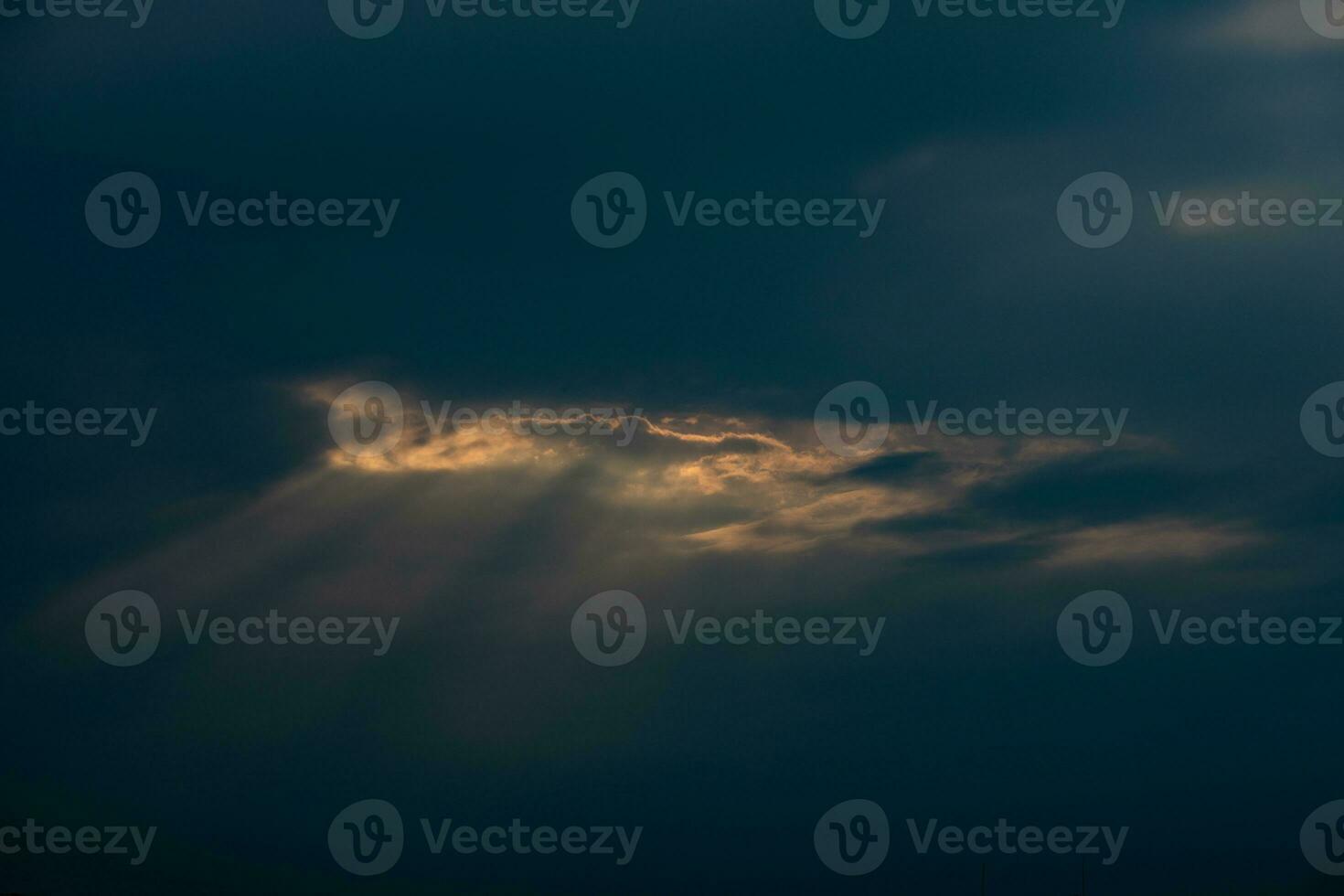 romantic western sky with sunrays and dark clouds forming the background photo