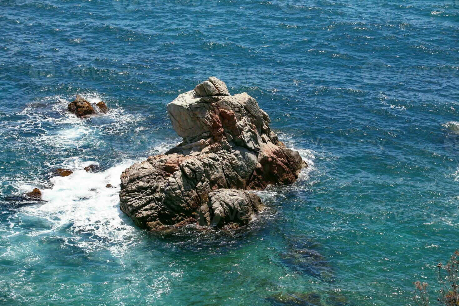 waves breaking on a coastal cliff in the blue sea, aerial view photo