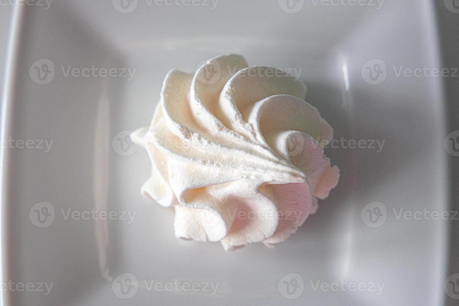 small white tasty sweet meringue on a white plate photo