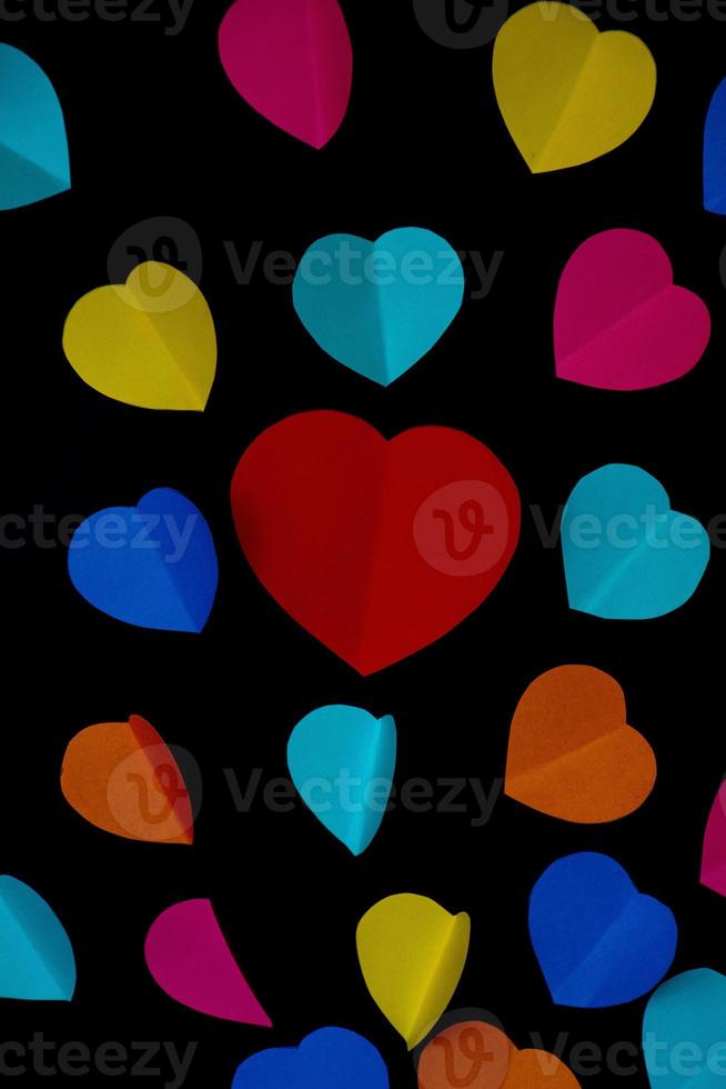 vistoso cortar fuera papel corazones en un negro suave antecedentes foto