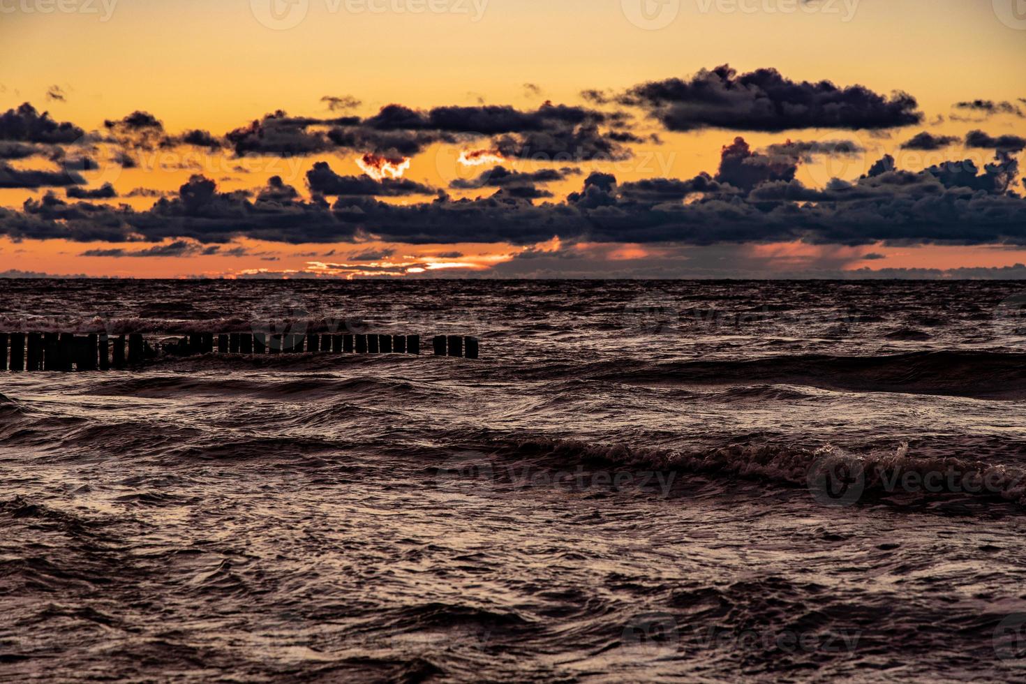 pintoresco calma puesta de sol con vistoso nubes en el costas de el báltico mar en Polonia foto