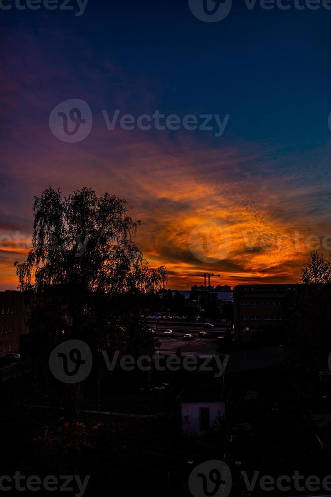 natural dramatic with clouds colorful urban sunset with construction crane photo