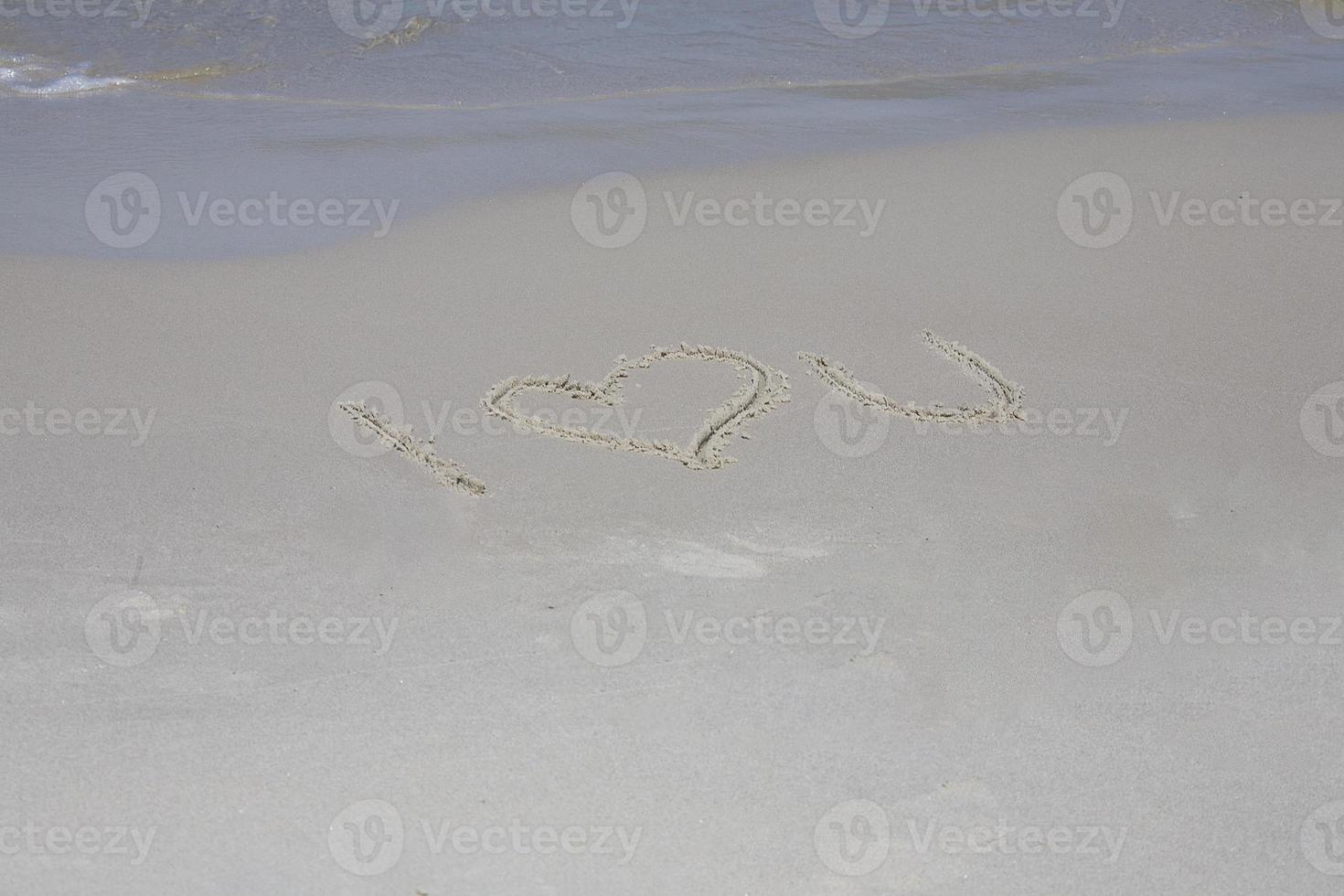 inscription on the sand on the sea shore I love you photo