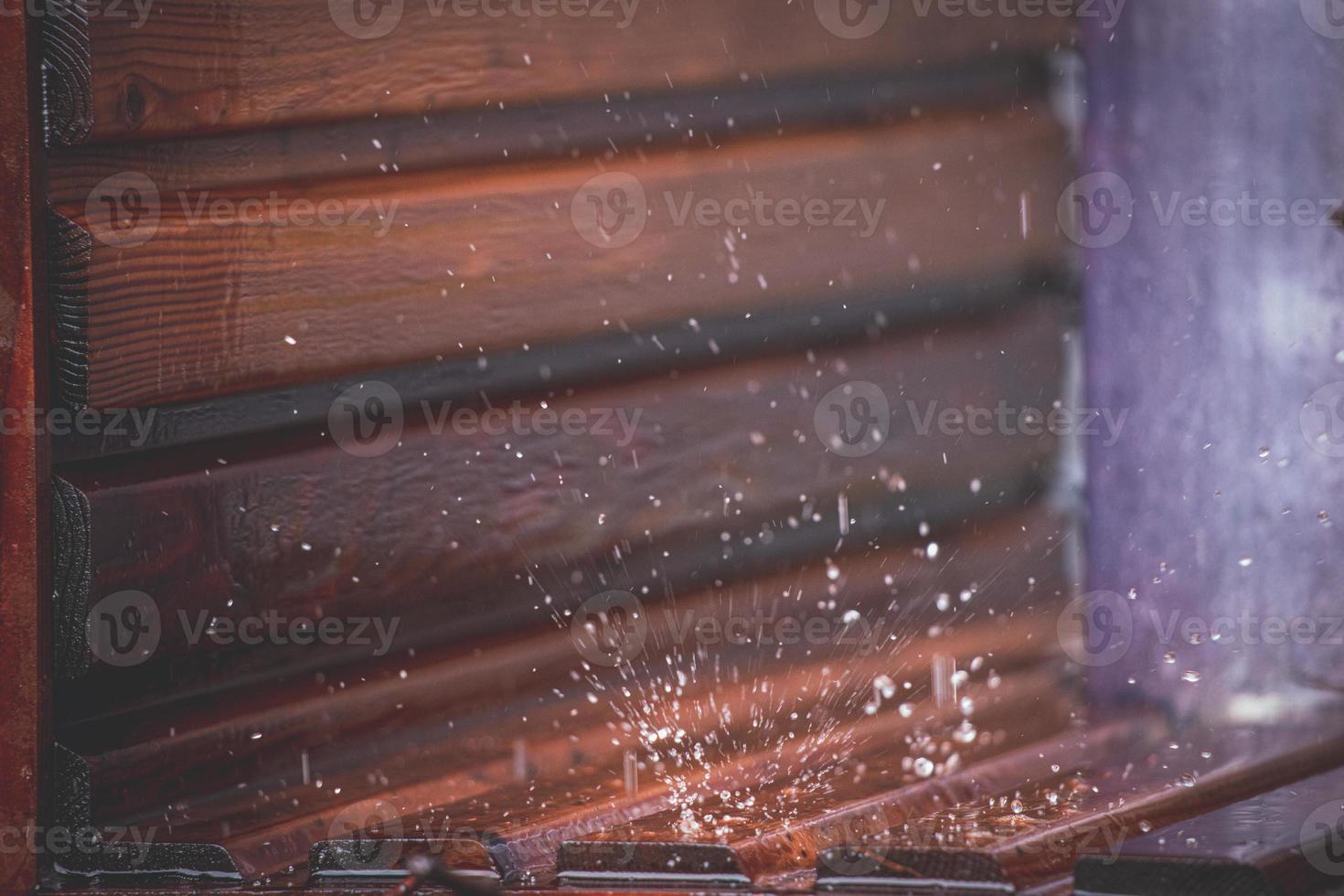 Close-up of drops falling on a wooden background in an urban graduation tower photo