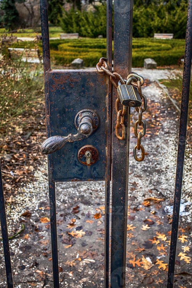 old retro vintage door fence with a large lock closed on a chain photo