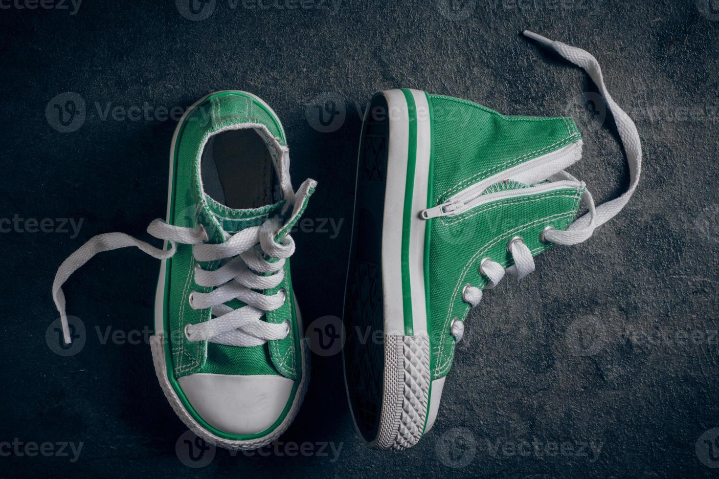 Kids sneakers on the black background photo