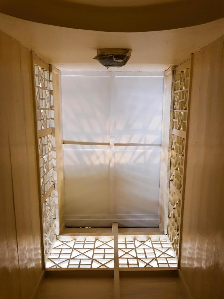 The ceiling is viewed from below in a room with a dominant cream color. photo