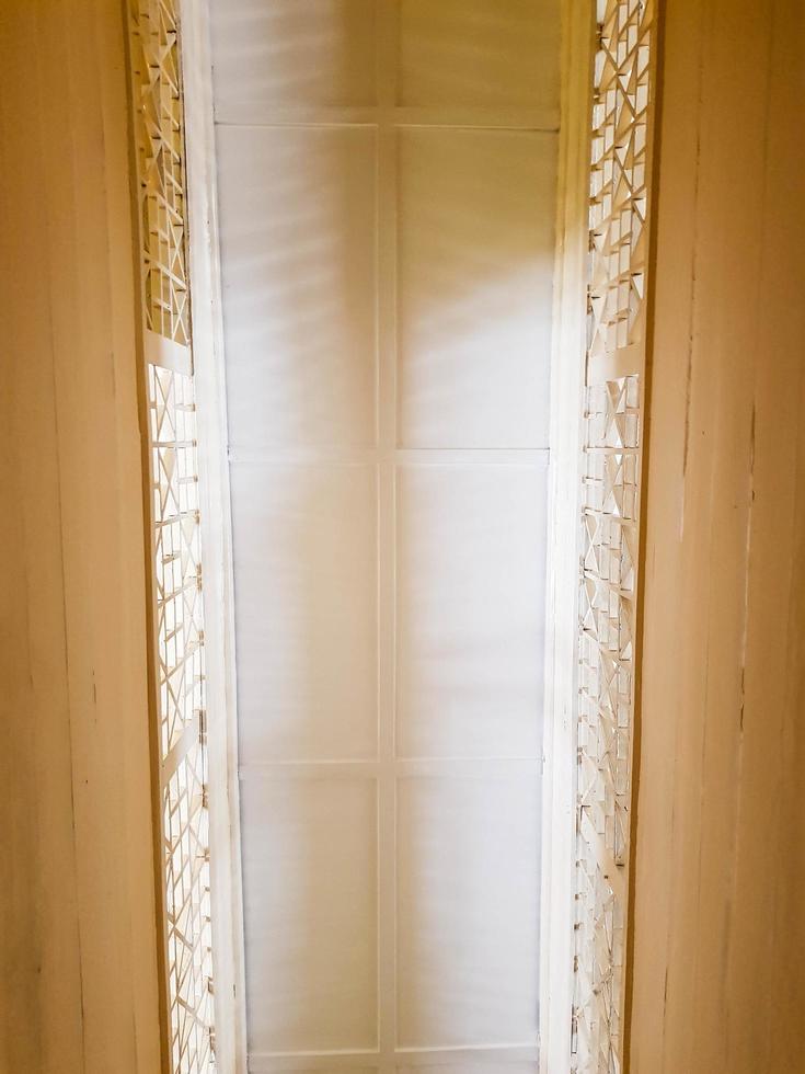 The ceiling is viewed from below in a room with a dominant cream color. photo