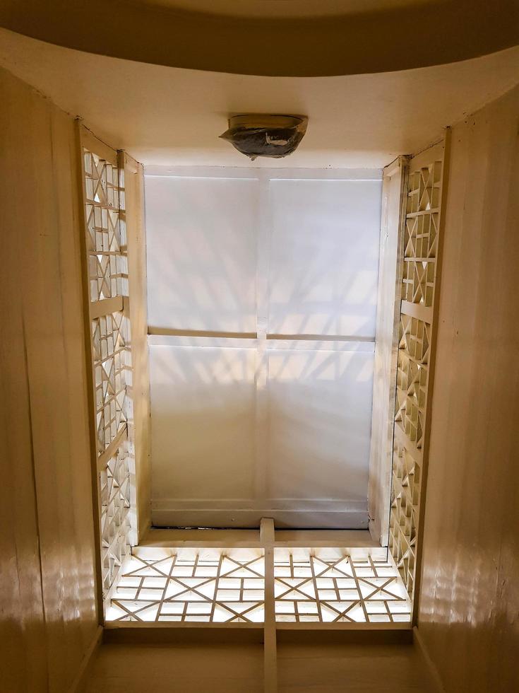 The ceiling is viewed from below in a room with a dominant cream color. photo
