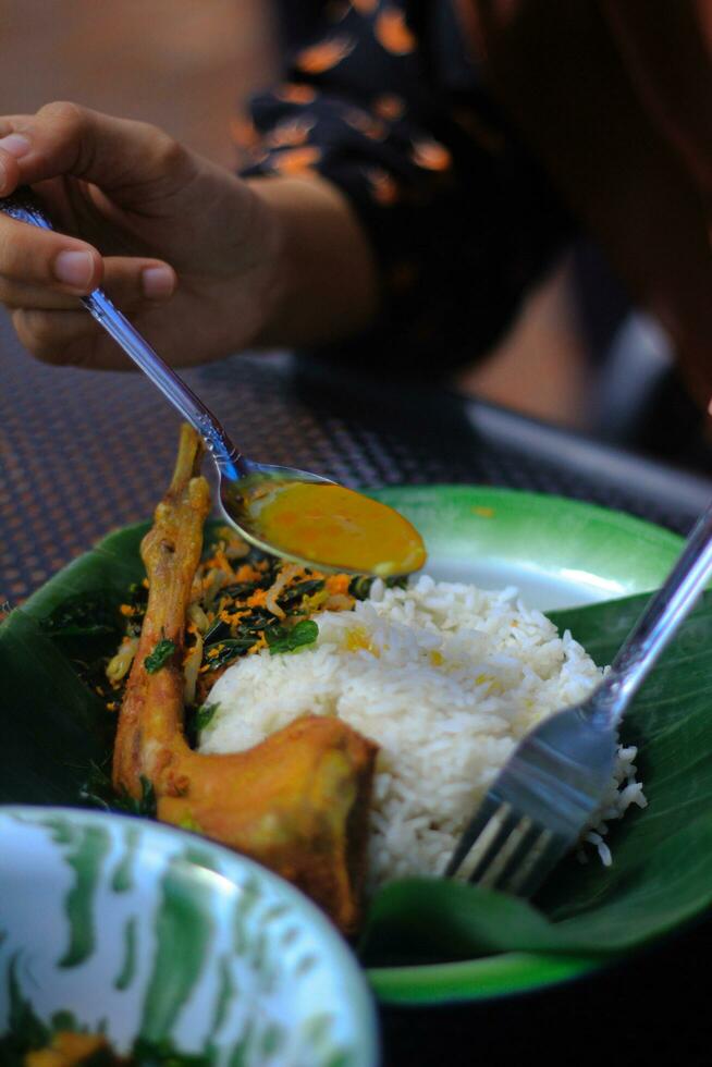 Fried chicken with curry paste and rice on green plate in restaurant photo
