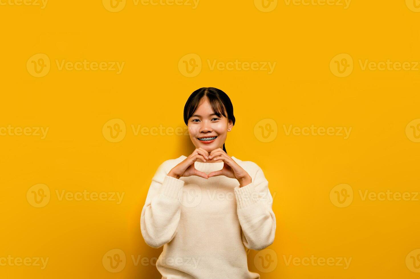 asian girl Beautiful wearing a white casual dress on a yellow background. Celebrate the victory with a happy smile and the winner's expression with a raised hand. happy expression photo
