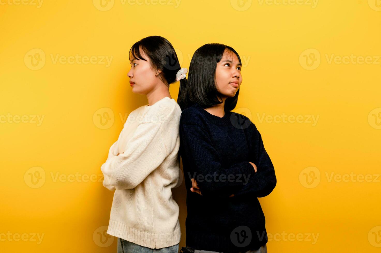 the intensity of communication misunderstanding Two friends don't talk to each other after a fight. behind the yellow background Filming of content about conflicts and misunderstandings photo