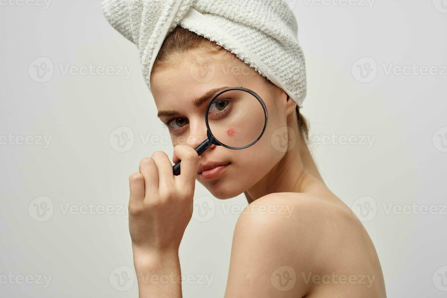 beautiful woman with a magnifying glass in hand skin problems photo