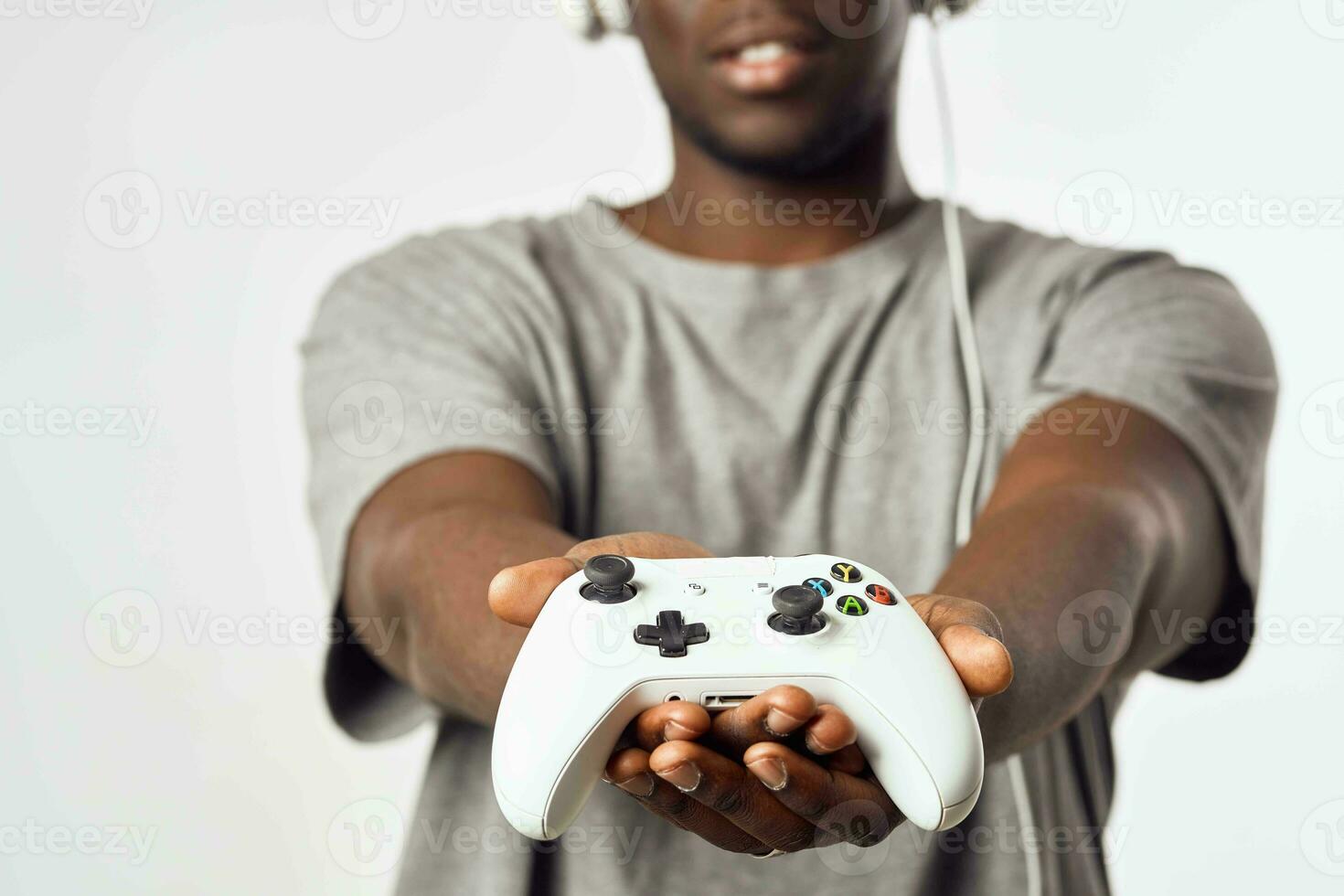 a man of african appearance in headphones with a gamepad in his hands plays video games technology photo