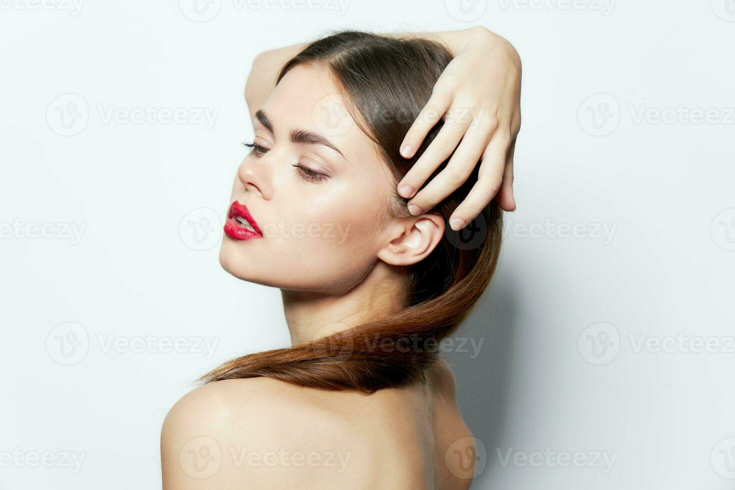 Woman naked shoulders attractive look red lips holds hand on head natural look photo