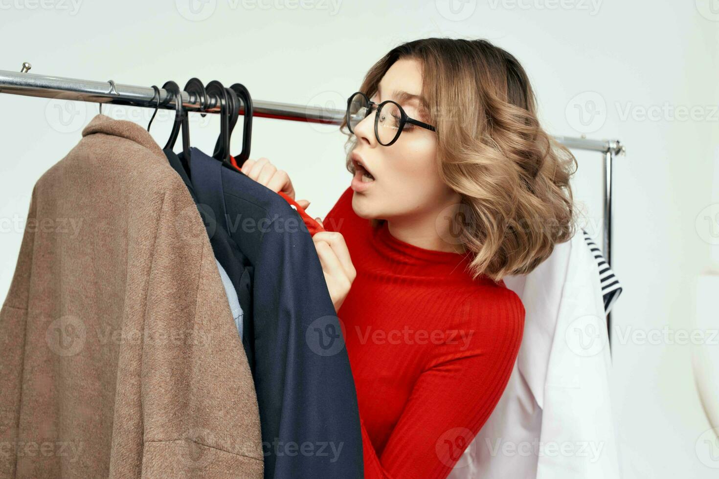 pretty woman in a red jacket near the wardrobe retail isolated background photo