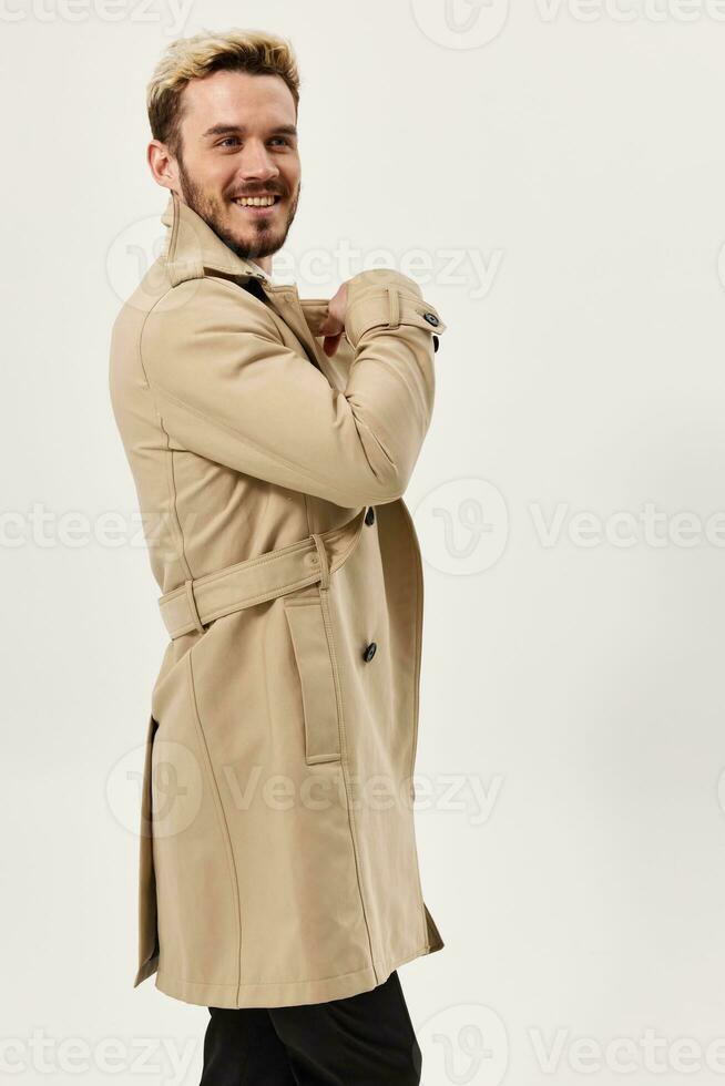 man fashion hairstyle beige coat studio light background photo