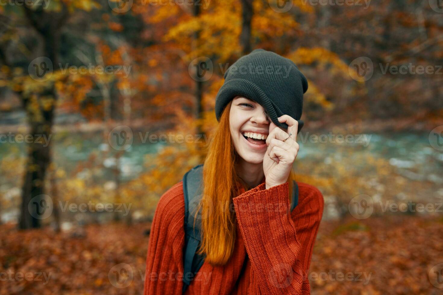 mujer en un sombrero y un suéter con un mochila en su espalda divertido otoño paisaje río foto