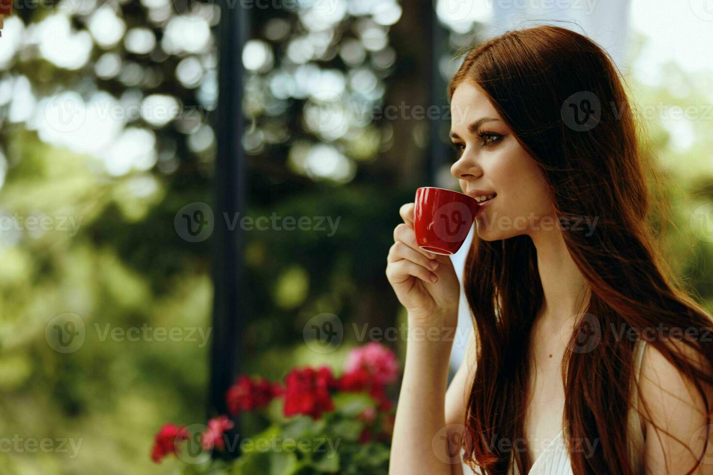 alegre mujer en un blanco vestir bebidas café al aire libre en un café inalterado foto