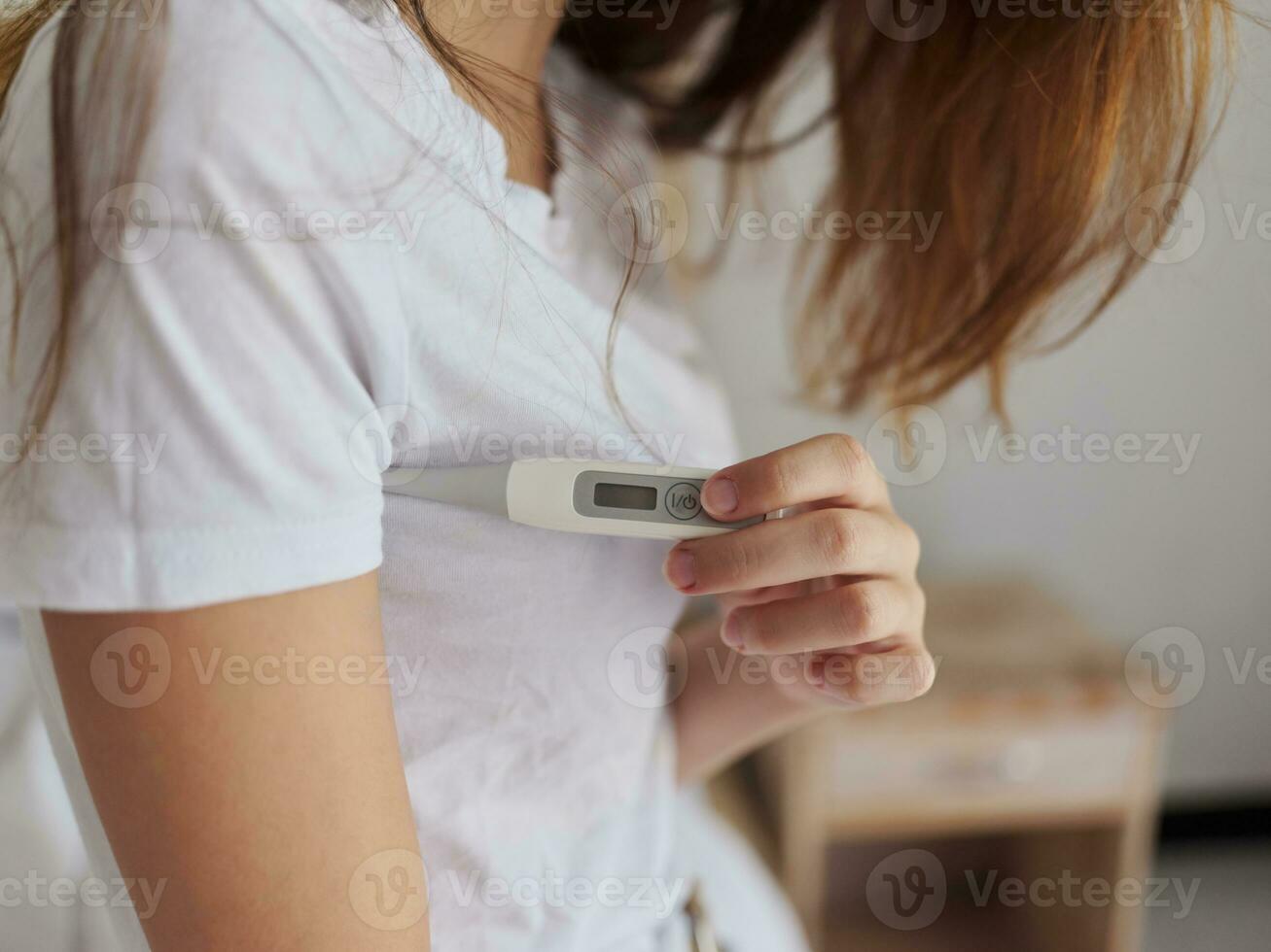 woman holding thermometer in hands checking temperature cropped view photo