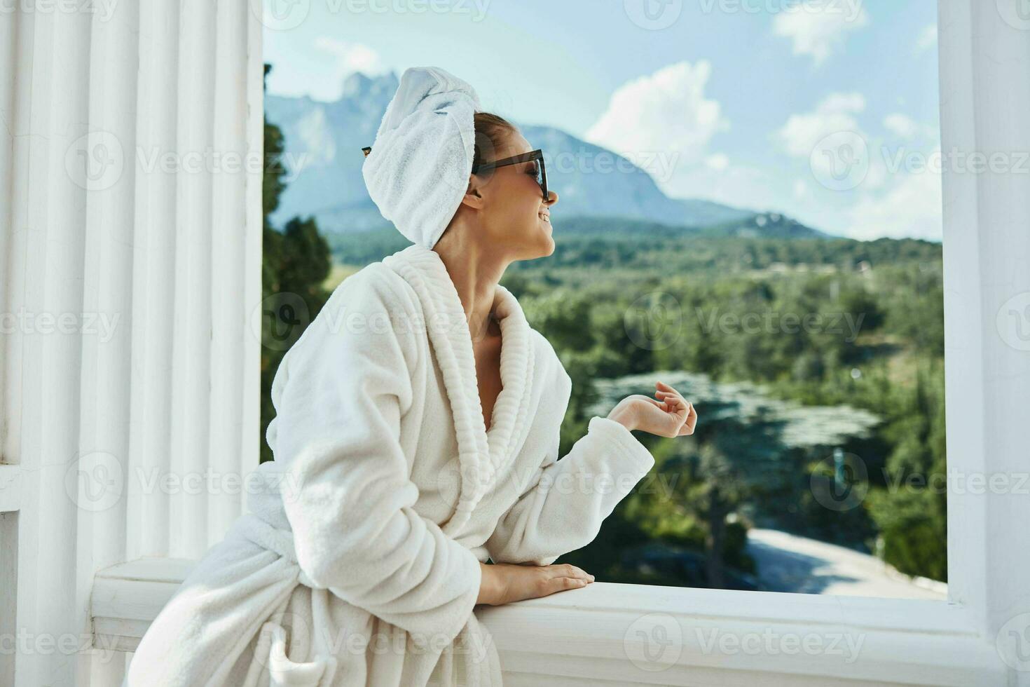 pretty woman in a white robe on the balcony bit on green nature Relaxation concept photo