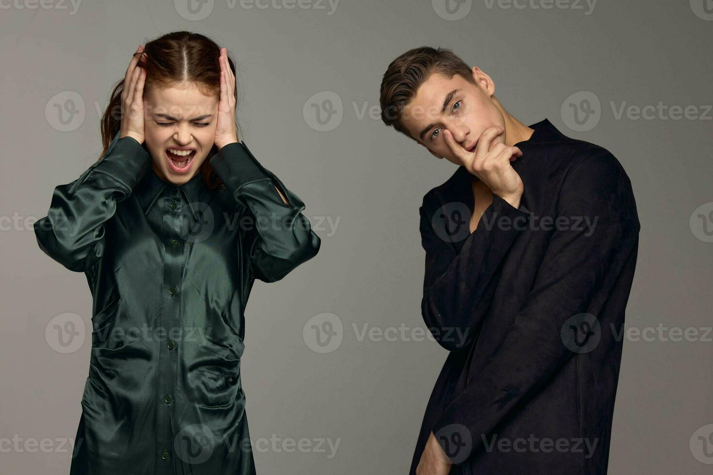 Calm man and irritated woman on gray background emotions conflict photo