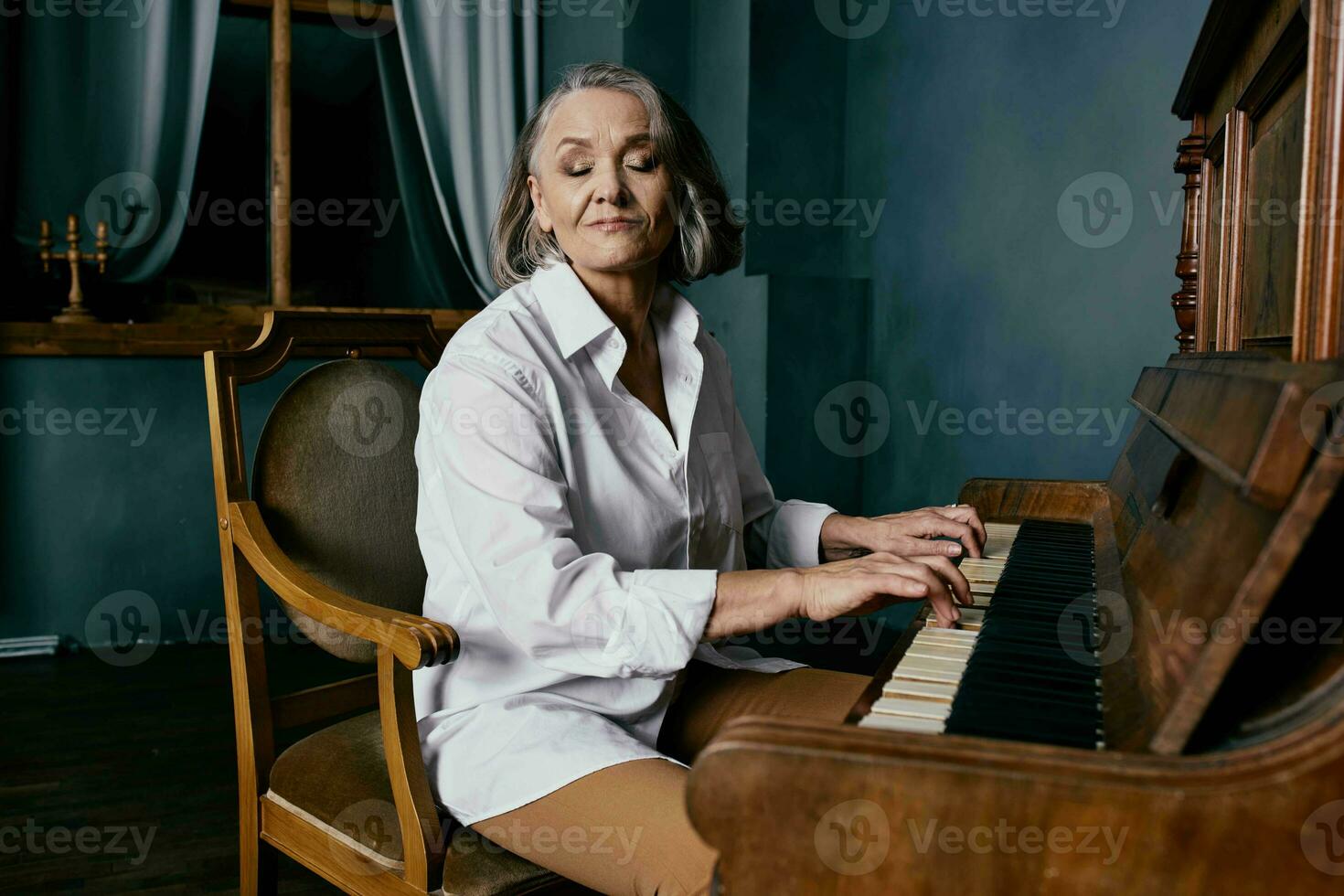 mayor mujer sentado en un silla cerca el piano música actuación foto