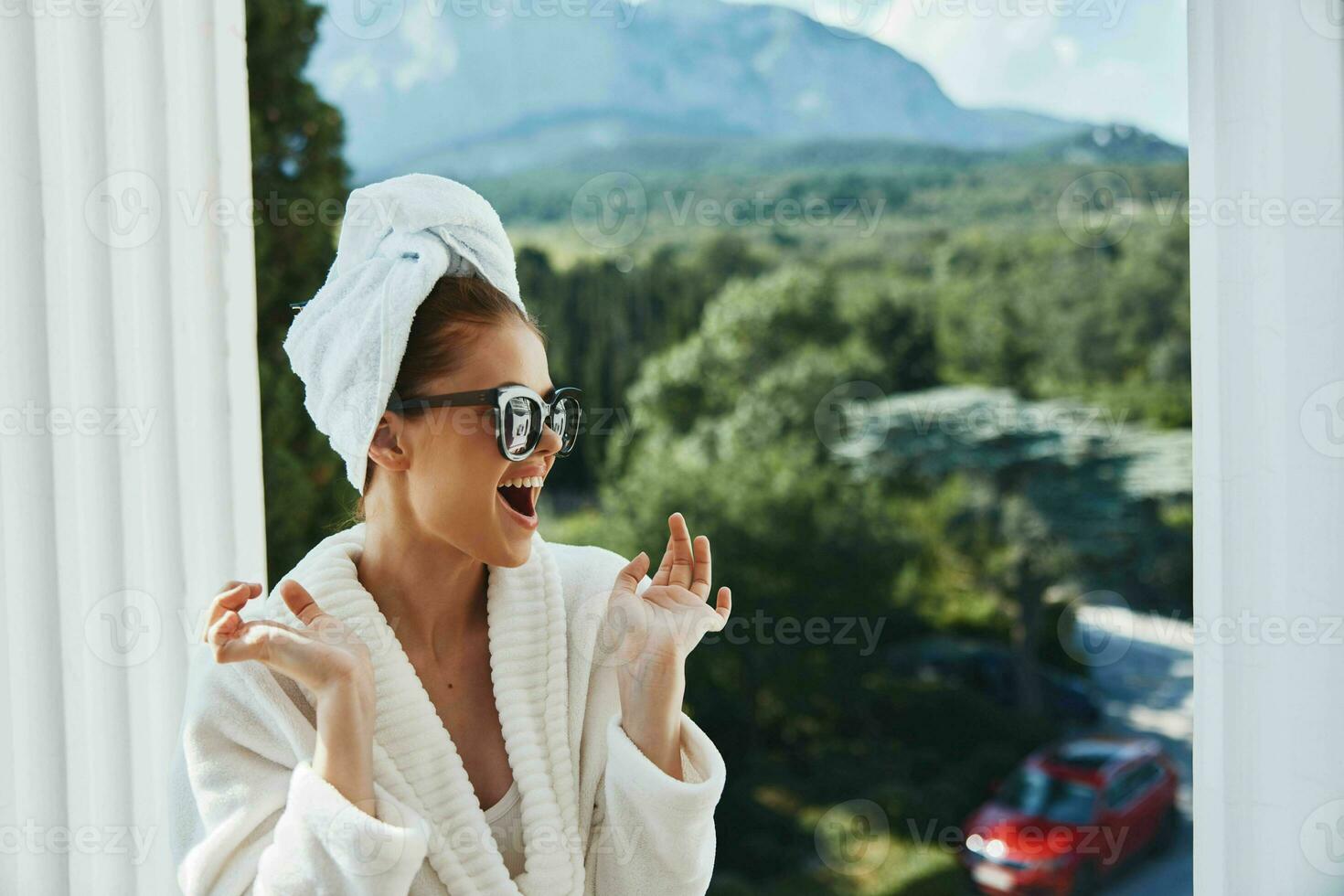 stylish woman wearing sunglasses posing in a bathrobe on a balcony rest Mountain View photo