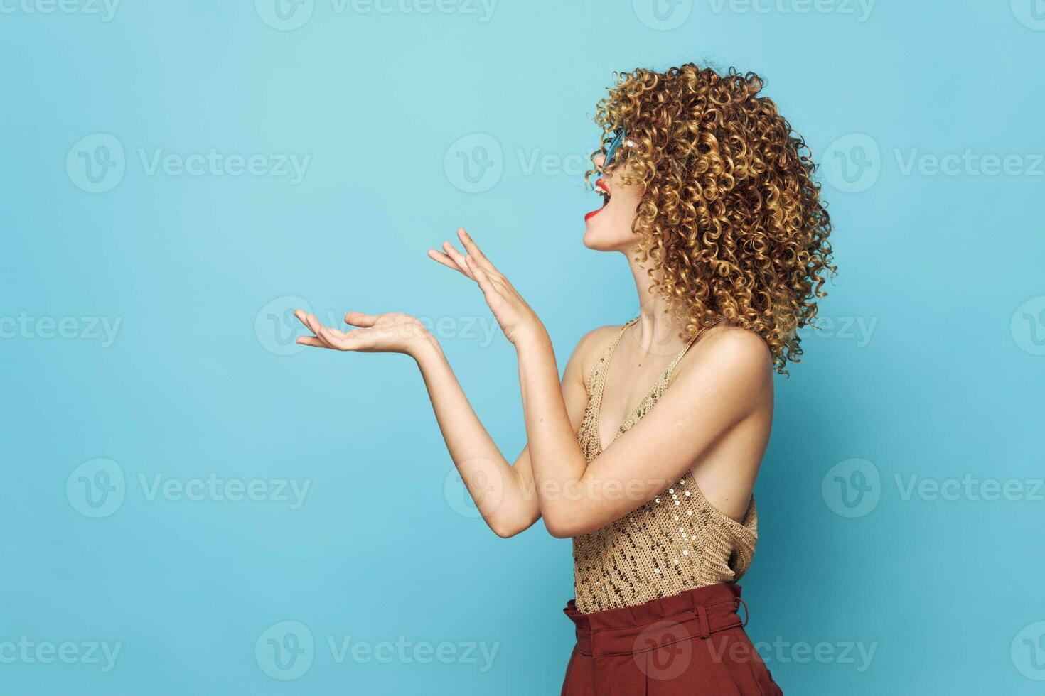 Attractive woman curly hair Gesturing hands side view blue background photo