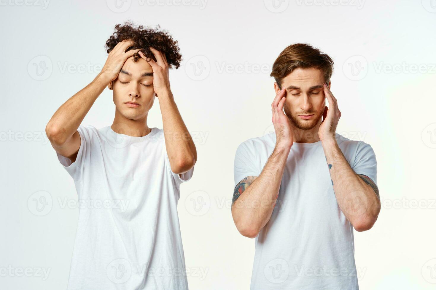 two friends in white t-shirts hold their heads emotions photo