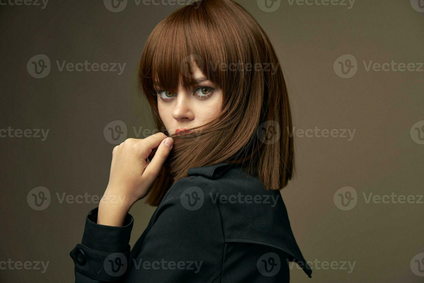 Charming lady European appearance black coat beige background photo