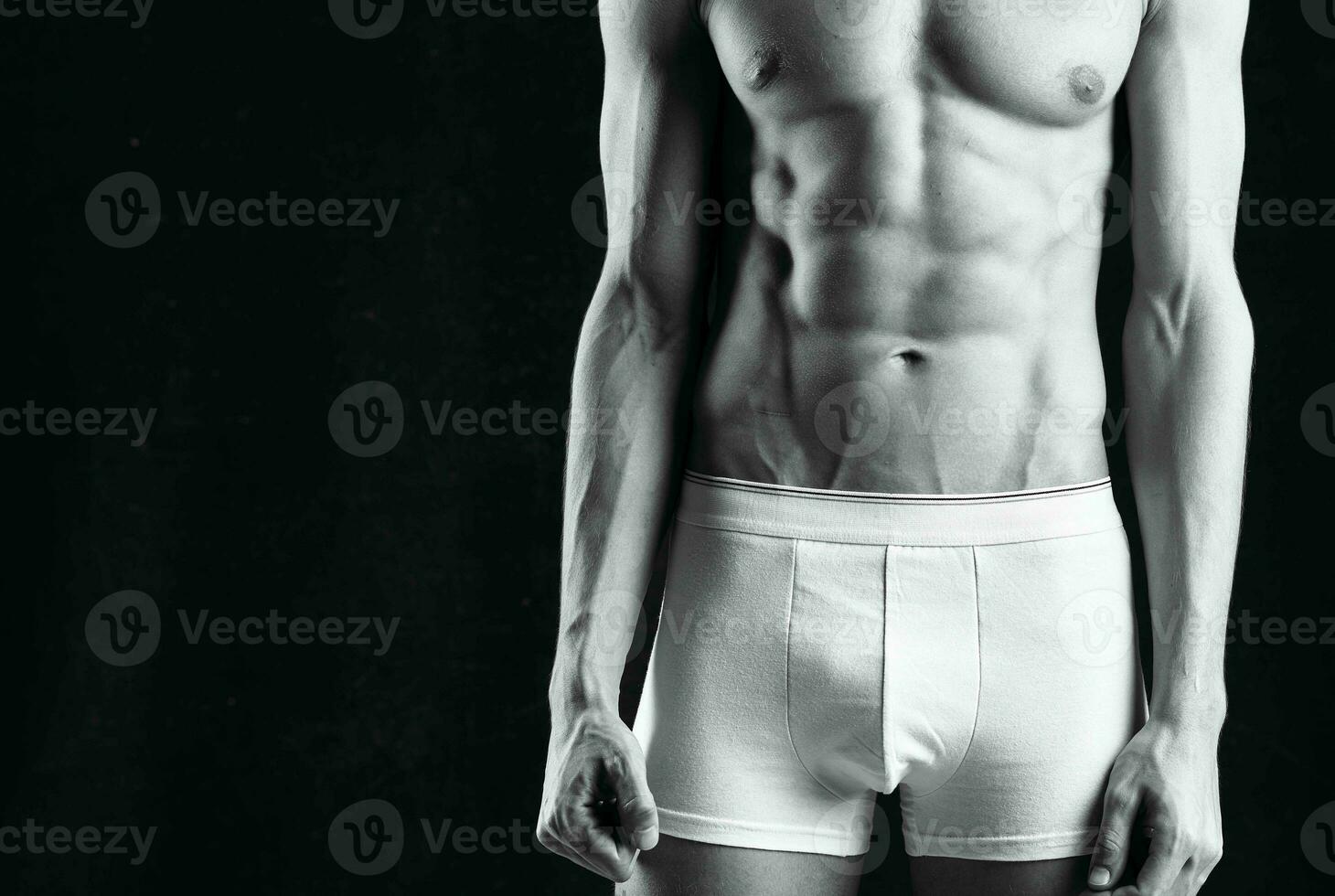 male athlete in white shorts inflated body bodybuilder the dark background photo