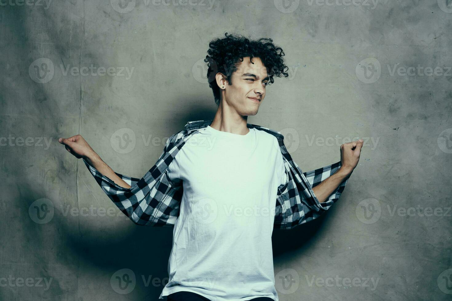 Cheerful guy curly hair plaid shirt studio cropped look lifestyle photo