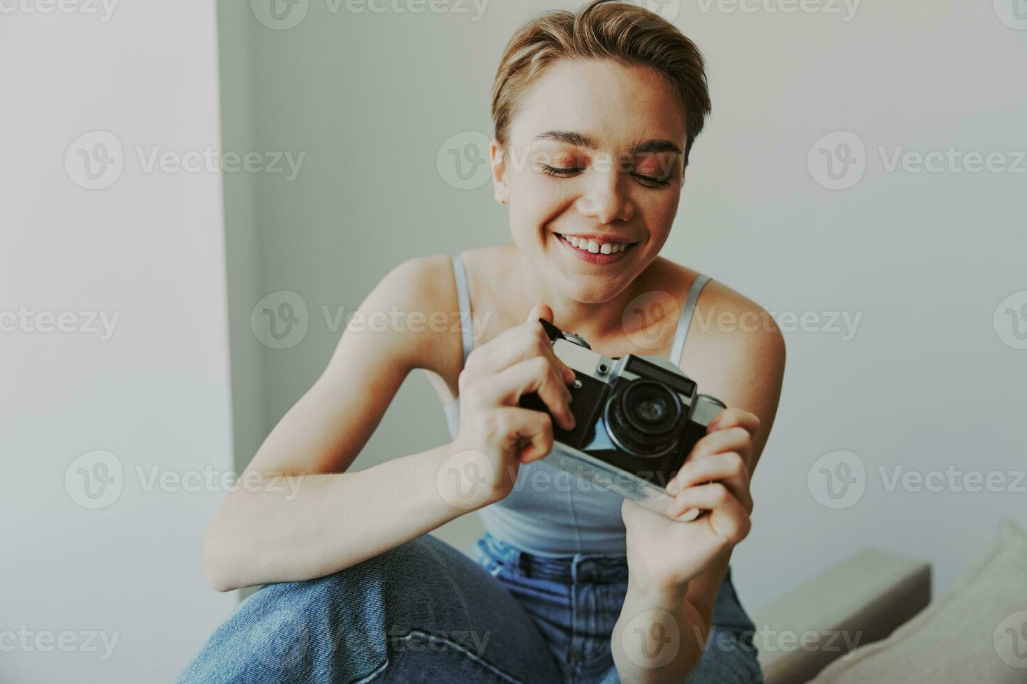 Woman photographer shooting in studio on old film camera at home on couch portrait, white background, free copy space, freelance photographer photo