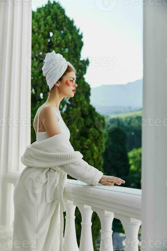 Woman in a bathrobe with patches on his face admires nature unaltered photo