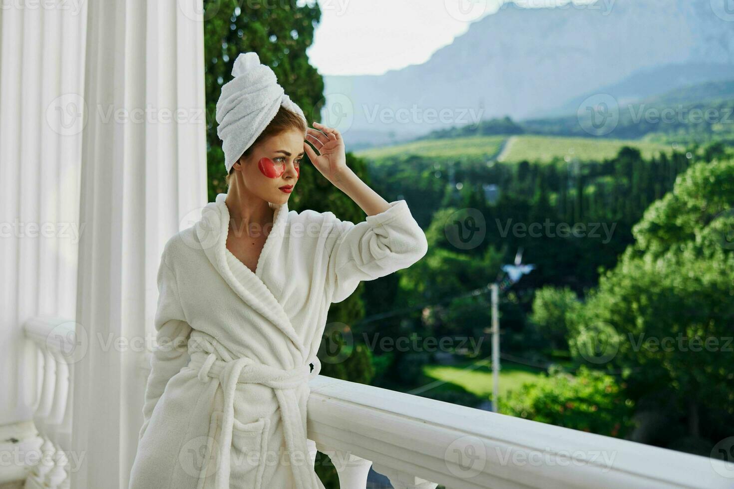 Sensual and beautiful woman in a white robe the balcony overlooks the mountains unaltered photo