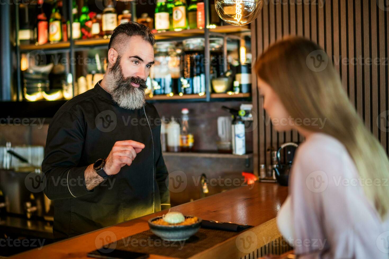 Young woman talking to sushi chef photo