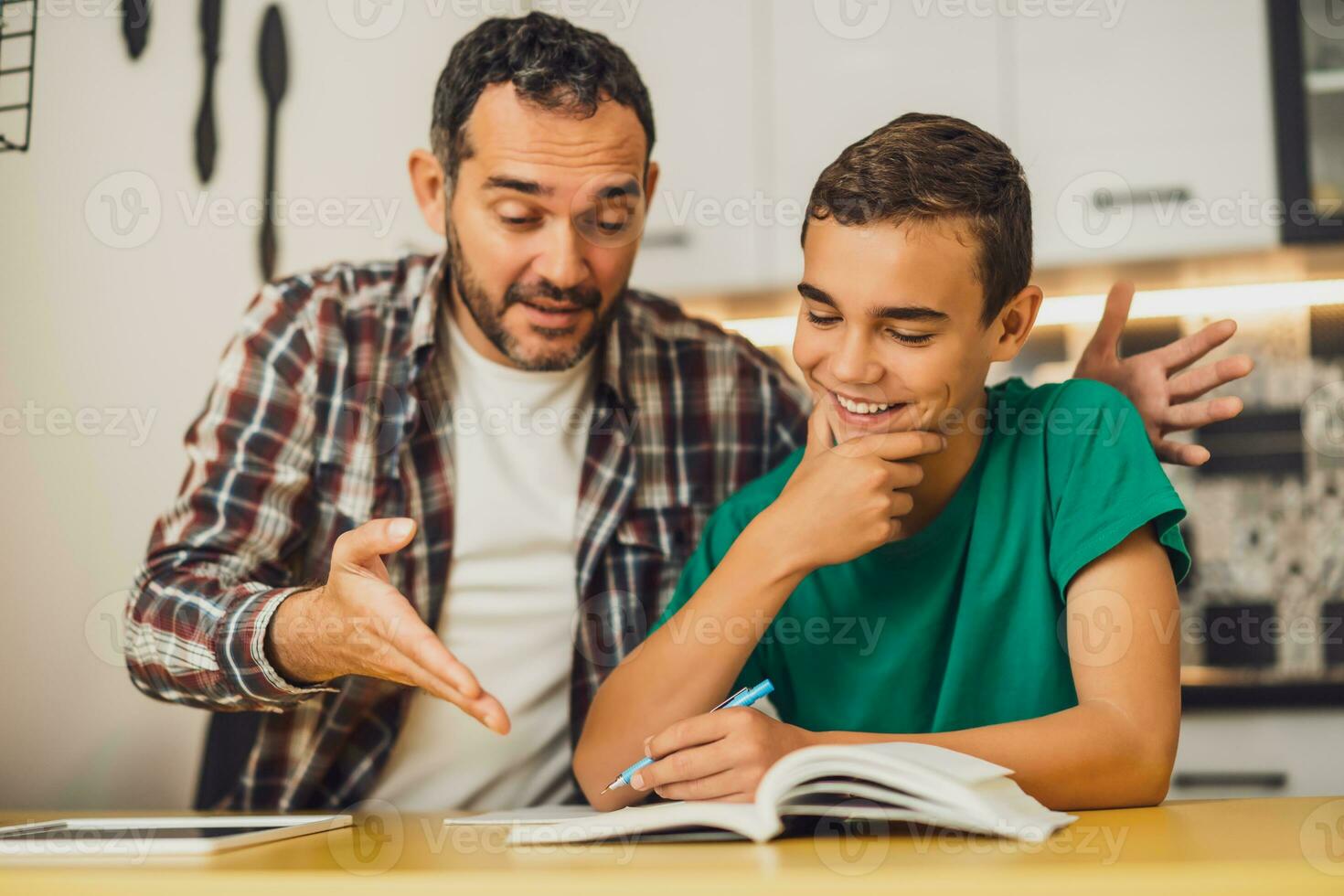 Father is helping his son with learning. They are doing homework together. photo