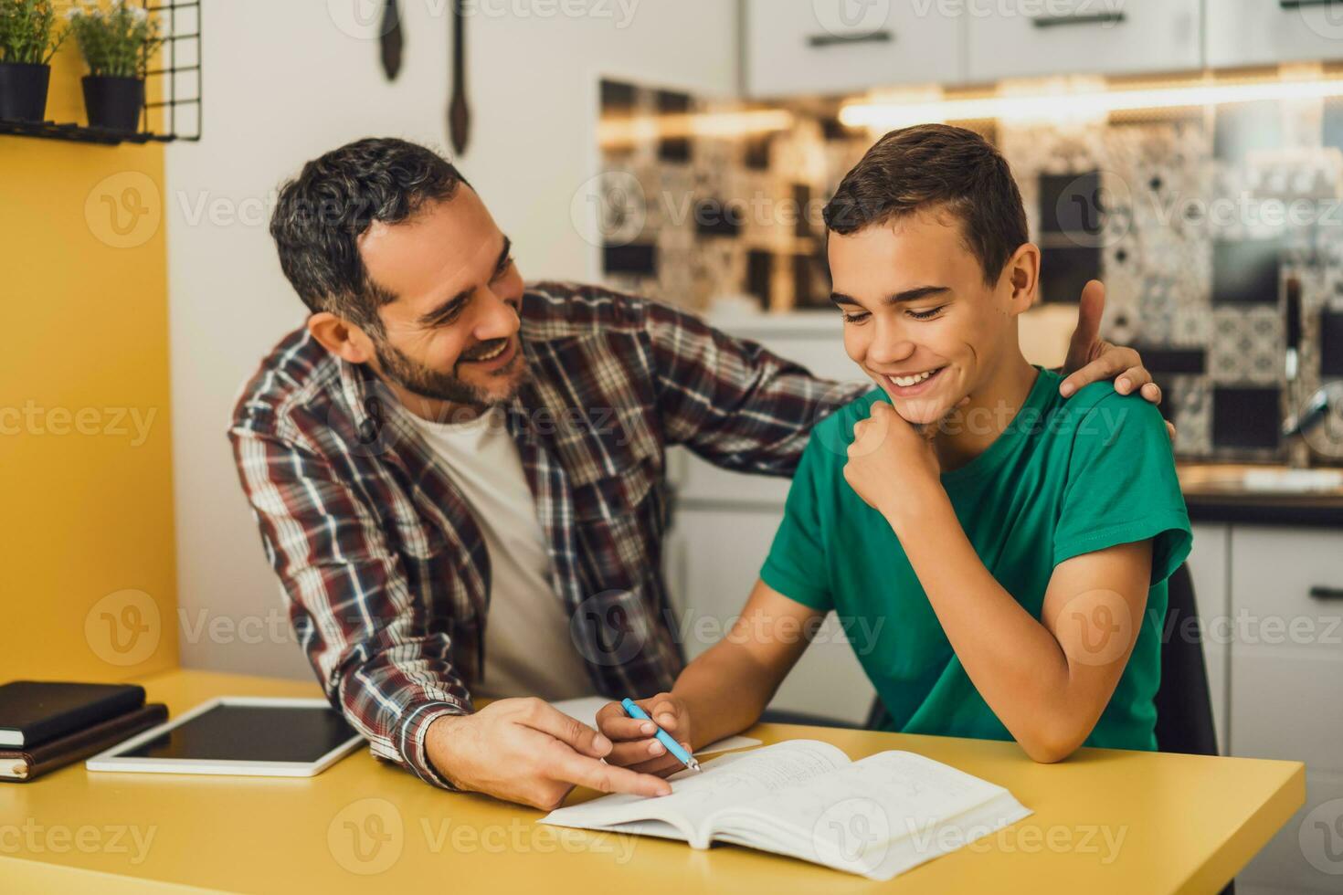 Father is helping his son with learning. They are doing homework together. photo